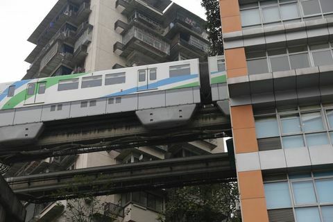 El tren ligero pasa a través del edificio residencial en Chongqing