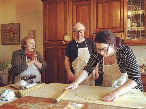 Tres personas en la cocina haciendo pasta en Italia