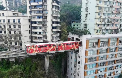 El tren ligero pasa a través del edificio residencial en Chongqing