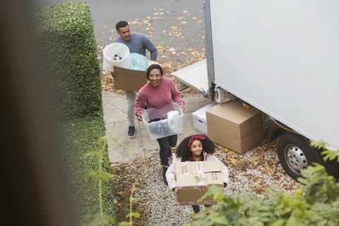 La familia se muda a una casa nueva, cargando cajas de una camioneta