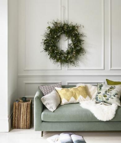 Winter Wonderland Sofá verde pálido y una corona de Navidad colgando de una belleza natural Corona de gran tamaño a medida, £ 250, Zita Elzesofa en Brera Moda Tomillo y Lambusa musgo, desde £ 2,395, gremio de diseñadores cojines l r oblongos en platino marga, £ 75 millones, gremio de diseñadores con botones cubiertos en cristal lunama, £ 90 millones, tela de christopher farr cuadrado en larochezinc, £ 87m, gremio de diseñadores con ribetes de cuero en plata, £ 36m, samuel sons geotile en chartreuse, £ 110, niki jones adachi celadon, £ 85, designerguild alfombra de piel de oveja, £ 80, mesa auxiliar de columna vertical cox cox twig, £ 875, taza pequeña pinch atro city, plato pequeño habitual de £ 46, £ 24 ambos emma johnsonceramics libro, propio del estilista