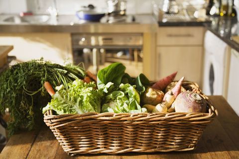 Verduras en la cesta en la mesa de la cocina