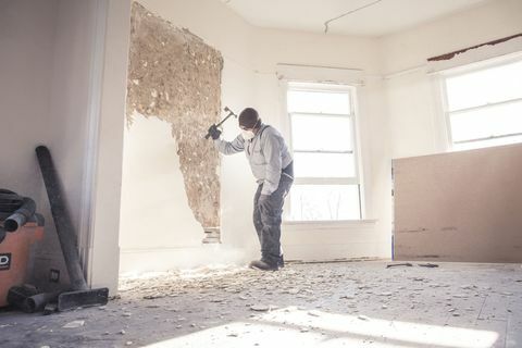 Trabajador de la construcción demoliendo muro