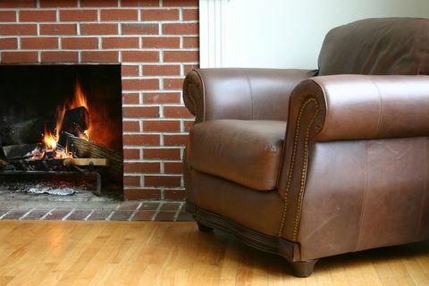 Silla de cuero, pared de ladrillo y chimenea.