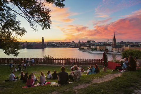 Las personas que tienen picnic en un parque con panorama de Estocolmo durante el atardecer, Suecia