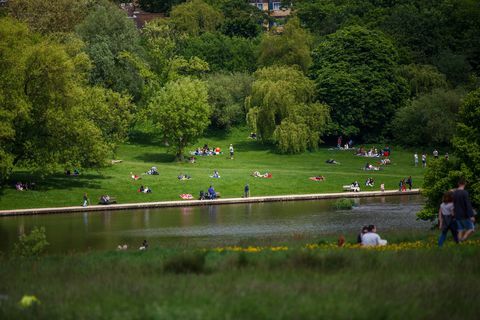 Los lugareños y turistas disfrutando del clima en Hampstead Heath, Londres