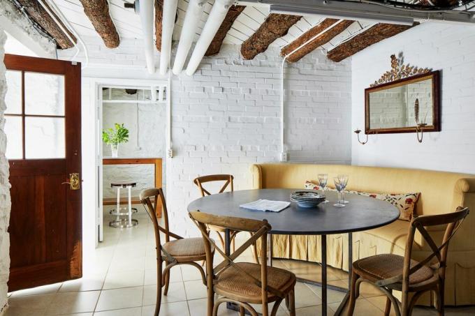 comedor con pared de ladrillo pintado de blanco