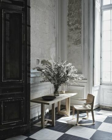 escritorio y silla con flores en jarrón encima de la mesa