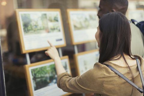 Pareja joven navegando por listados de bienes raíces en la tienda