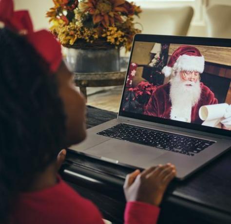 una niña hablando con santa claus en una videoconferencia por computadora