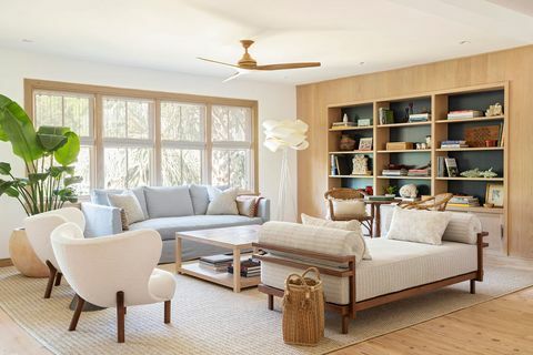 sala de estar, biblioteca, diván blanco con brazos de madera, sofá azul, sillones blancos