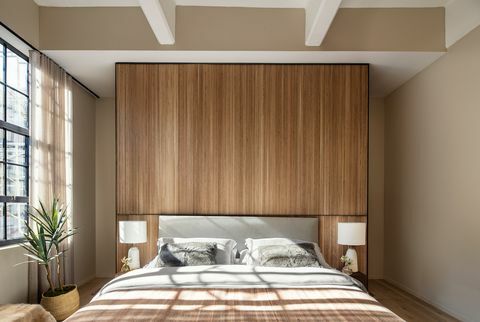 dormitorio, pared de madera, cabecero gris, lámparas de mesa blancas,