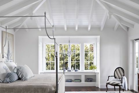 dormitorio, vigas de madera blancas, marco de cama de cobre, repisa de ventana y asiento