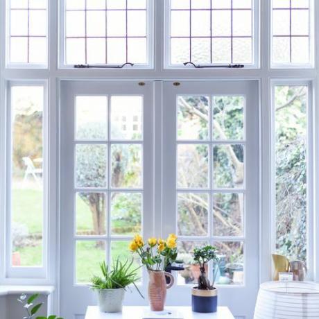 elegante interior de habitación con puertas francesas y colores neutros claros en una casa moderna