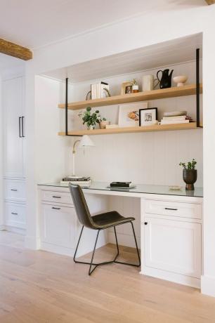 una cocina blanca con una silla negra