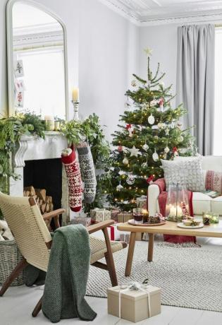 sala de estar decorada con medias y un árbol de navidad