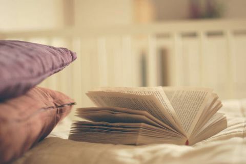 Un libro abierto y dos almohadas en la cama.