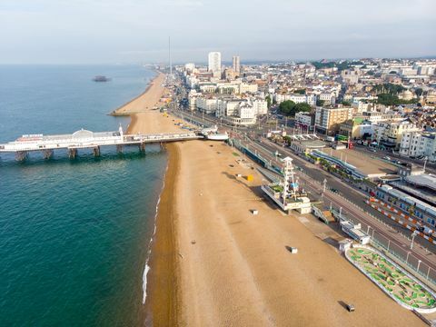 Foto aérea del famoso muelle y océano de Brighton ubicado en la costa sur de Inglaterra, Reino Unido, que forma parte de la ciudad de Brighton y Hove, tomada en un día soleado y brillante que muestra las atracciones del recinto ferial.