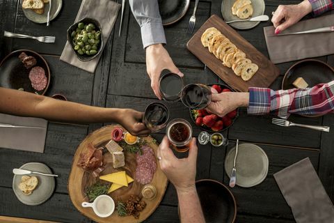 Vista aérea de amigos que comparten una comida: amigos que comparten charcutería y tapas con vino y cerveza.