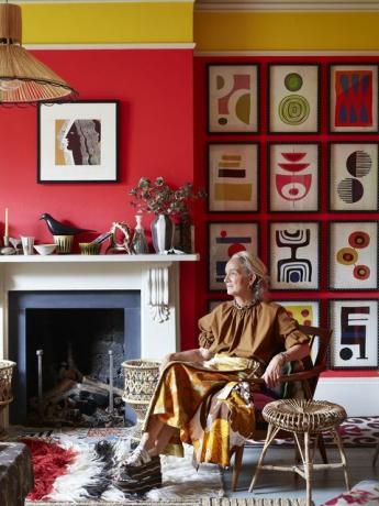 Lucinda Chambers sentada junto a la chimenea en una sala de estar