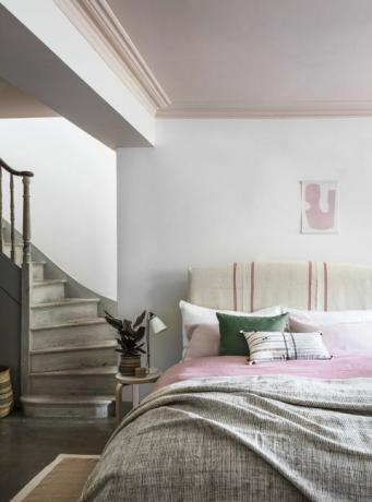 escalera que conduce al dormitorio con techo rosa