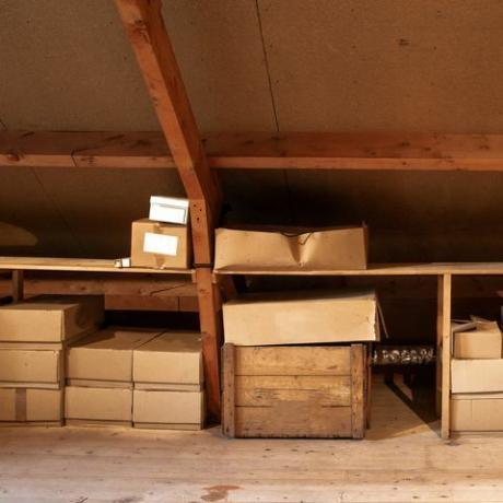 antiguo interior de ático de madera con cajas de cartón antiguas para almacenamiento o mudanza, cerrar