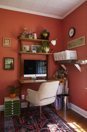 estudio, pared pintada de rojo, escritorio marrón, silla blanca