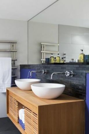 Mueble bajo lavabo con lavabo blanco y fondo gris