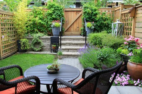 Pequeño jardín adosado con muebles de patio en medio de la flor de lavanda