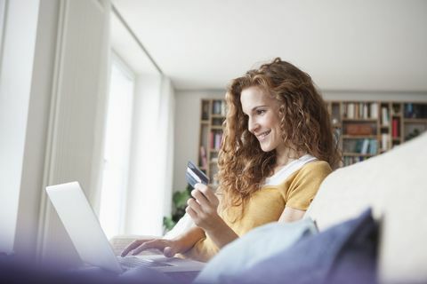 Mujer sonriente en su casa de compras en línea