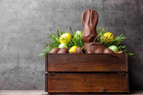 Conejito de Pascua tradicional de chocolate y huevos dentro de una caja de madera