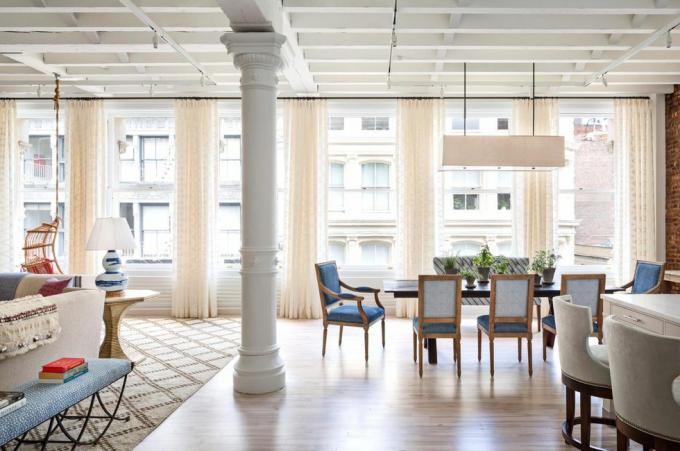 mesa de comedor en una habitación abierta con ventanas altas