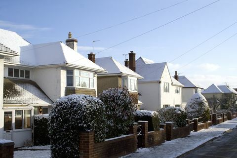 Una hilera de casas inglesas cubiertas de una fina capa de nieve.