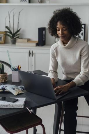 Mujer que trabaja en su oficina en casa usando una computadora portátil