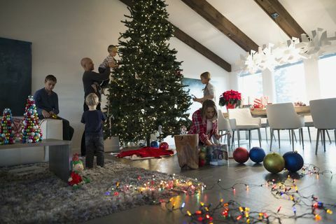 Familia decorando el árbol de Navidad en la sala de estar