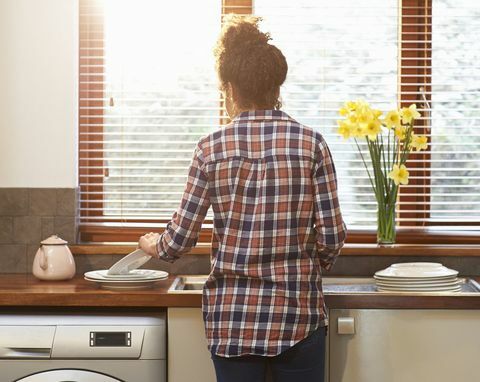 Mujer lavando vajilla en la cocina