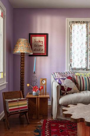 salón morado con lámpara de pie de madera y muebles