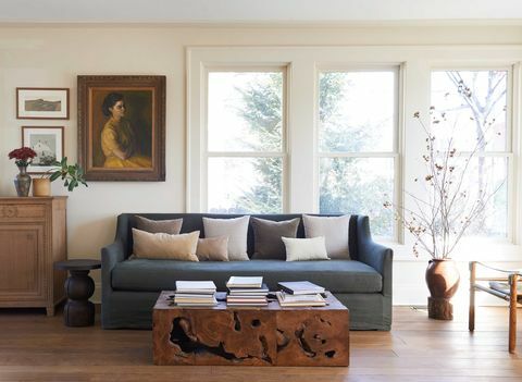 sala de estar, sofá verde, mesa de café de madera, libros de mesa de café, arte de la pared